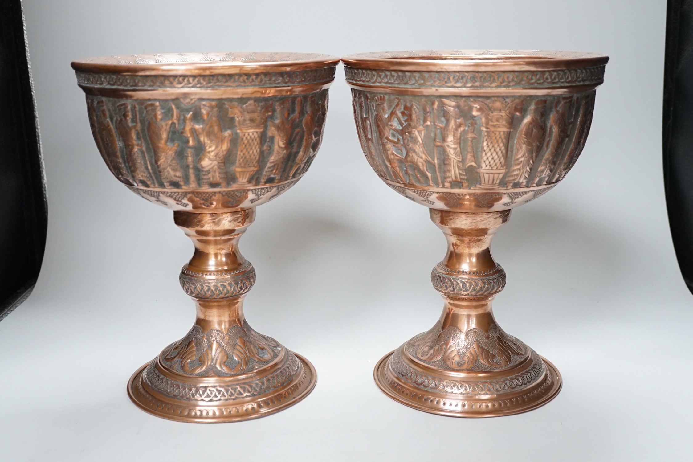 A pair of Persian copper figural decorated chalices, 27cms high